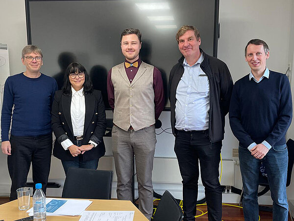 Gruppenbild der Promotionskommission und Promovent