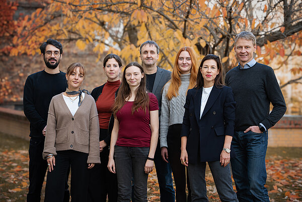 Team STARTDUST 8 Personen stehen für ein Gruppenbild auf einer herbstlichen Wiese
