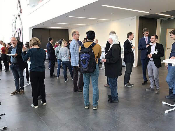 Lunch & Learn 2019 an der HTWK Leipzig (Foto: Sharon Geißler) Leute unterhalten sich an Stehtischen im Foyer.