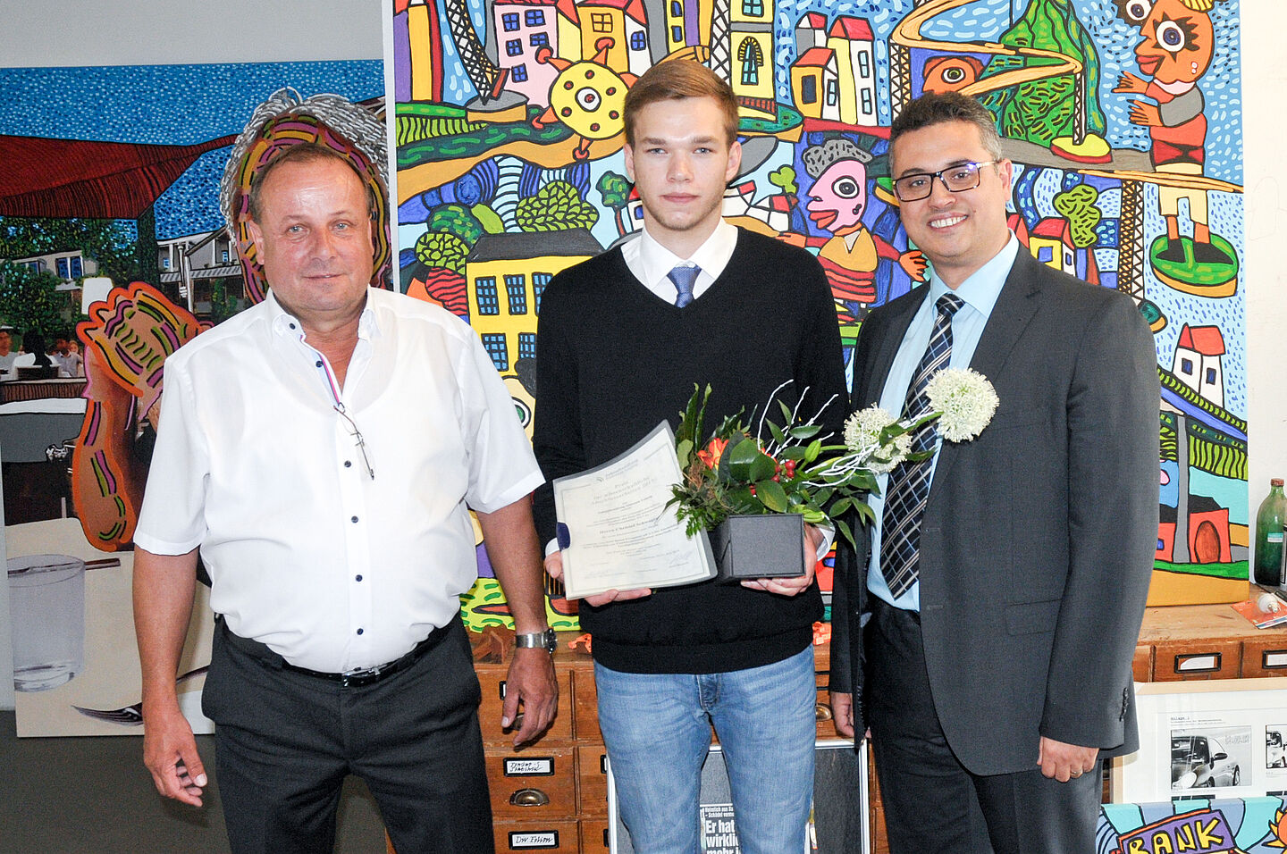 Der Preisträger Christoph Schwager mit Prof. Faouzi Derbel (Betreuer der Bachelorarbeit, rechts) und Dietmar Müller (Leiter Engineering Elektrotechnik bei der MIBRAG). 