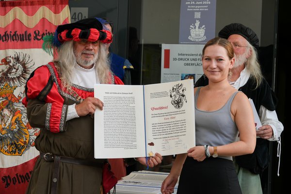 Das Überreichen des Gautschbriefs Der Gautschmeister überreicht der nun ehemaligen und sichtlich stolzen Kornutin den aufwendig gestalteten Gautschbrief.