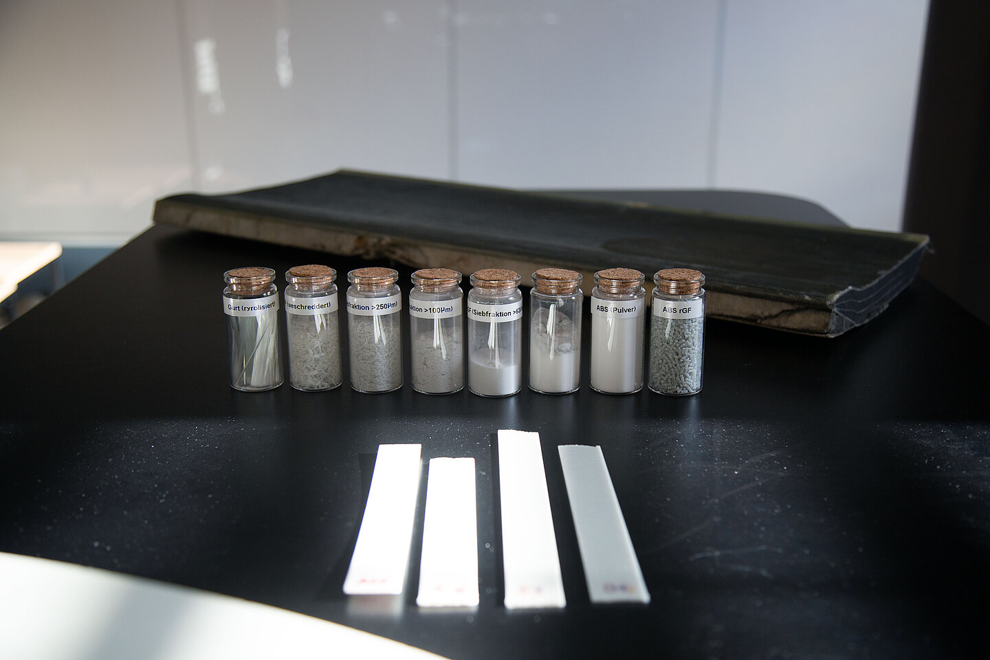 Materialproben Fläschchen mit grauem Pulver stehen auf einem Tisch
