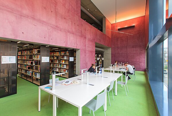 Hochschulbibliothek der HTWK Leipzig. (Foto: Swen Reichhold/HTWK Leipzig) Drei Personen sitzen mit Abstand an Tischen in der Bibliothek.
