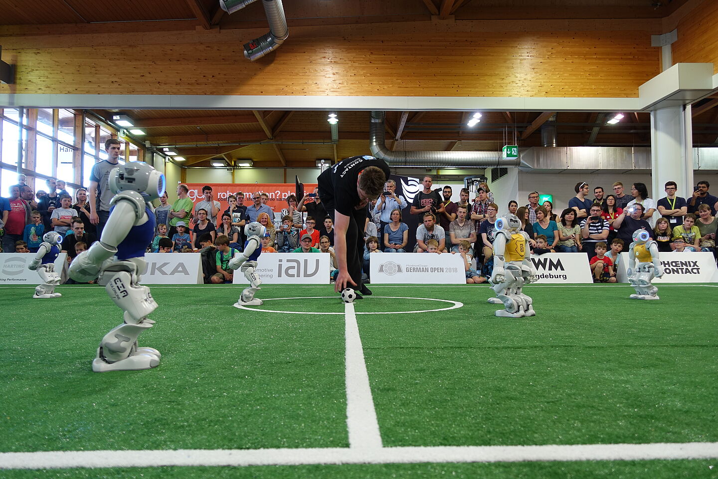 humanoide Fußballroboter auf dem Feld, Anstoßß durch Schiedsrichter