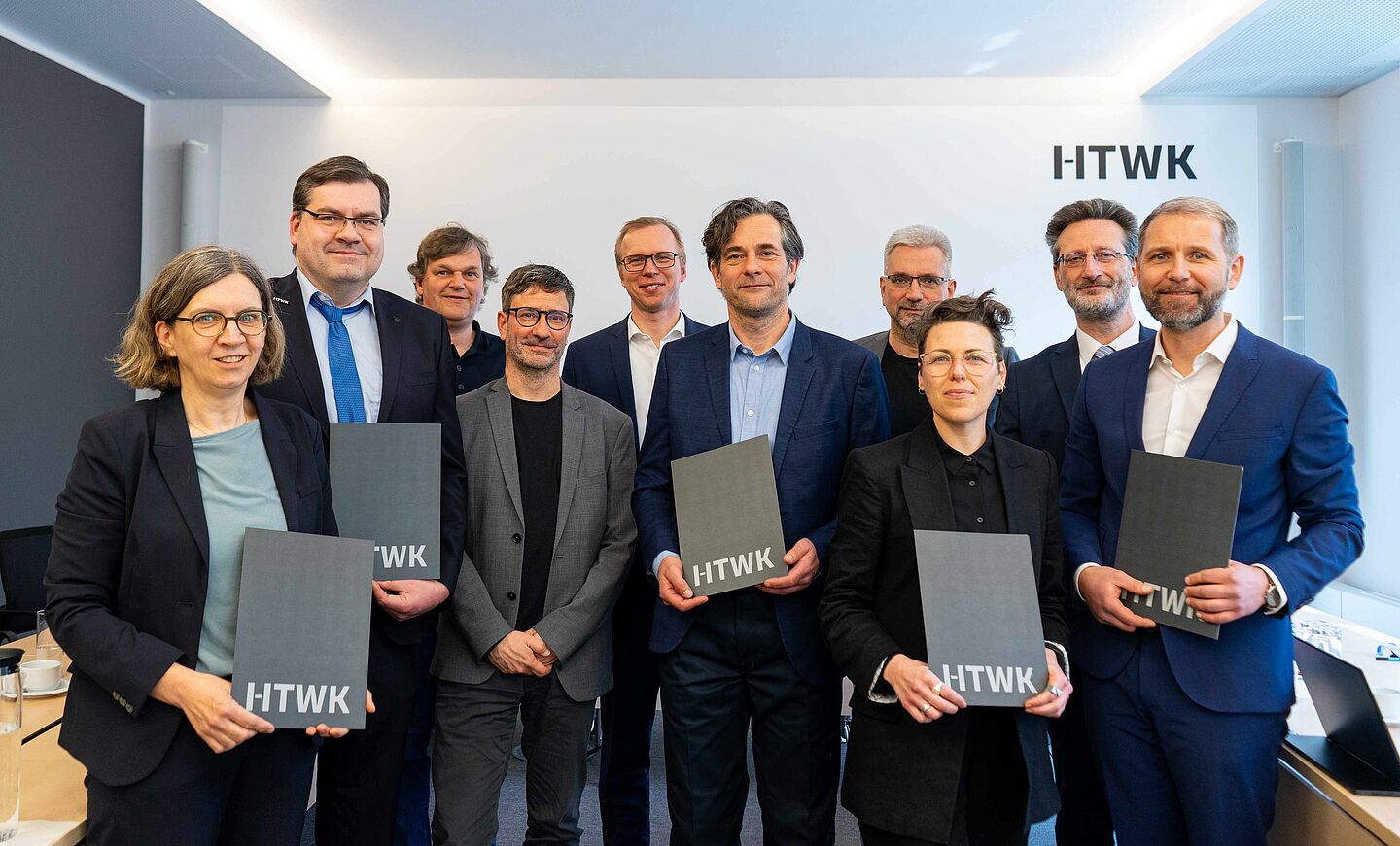 Gruppe von zehn Personen mit Urkunden in den Händen