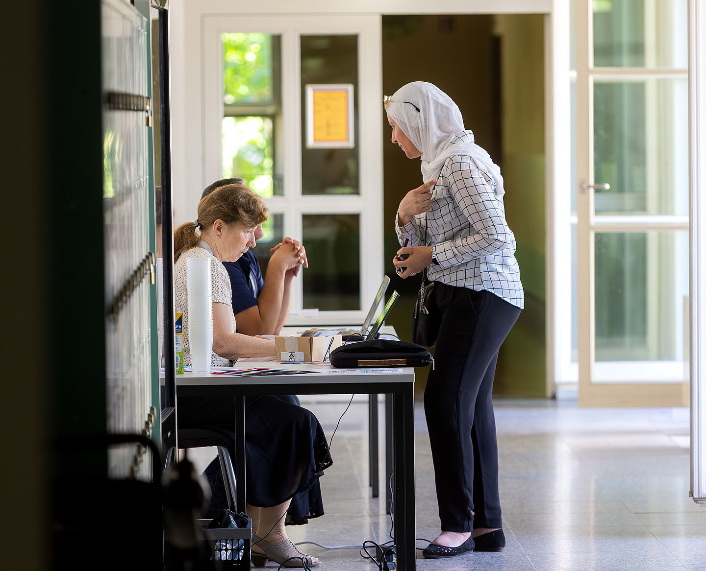 Eine Frau meldet sich am Tresen an