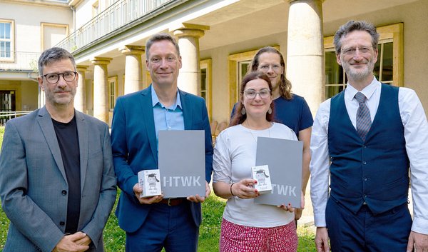 Gruppe von fünf Personen steht in einem HOf