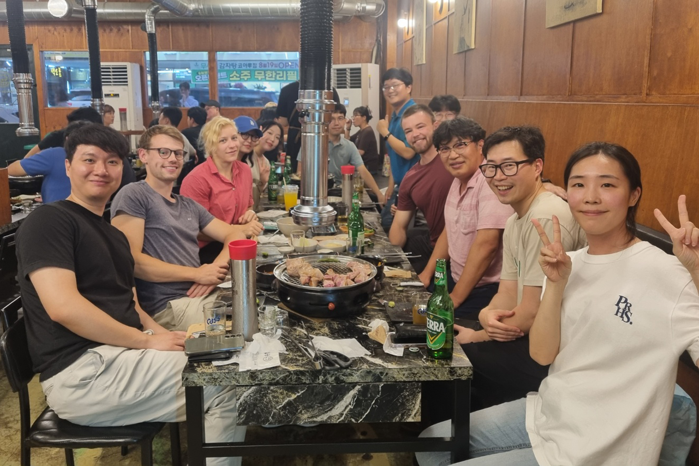 KIST Gastgeber aus Südkorea schauen in Kamera, gemeinsames Barbecue mit Philipp Johst