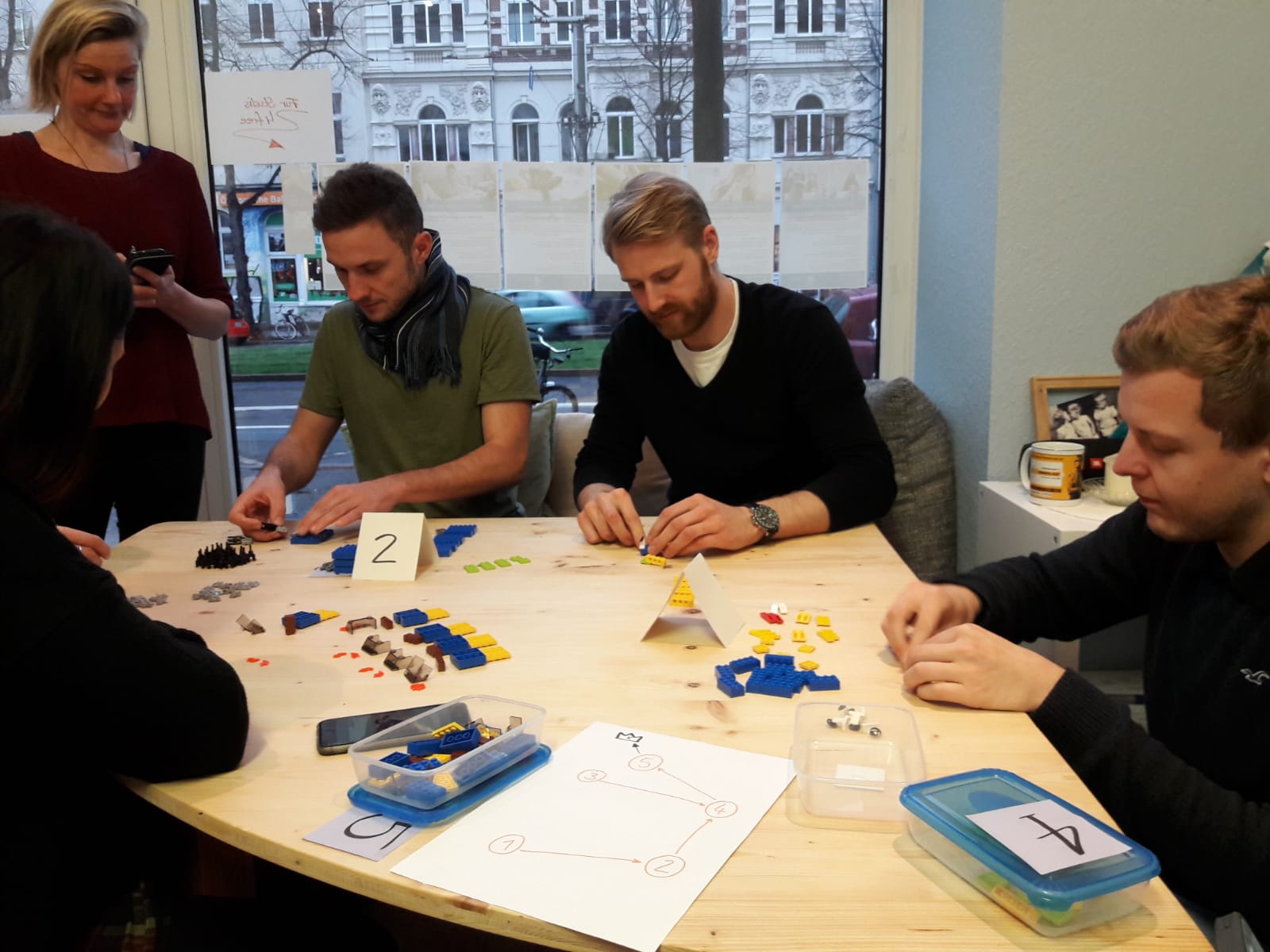 Workshop der LEAN Management Hochschulgruppe Eine Gruppe von Studierenden sitzt an einem Tisch und baut Lego zusammen.